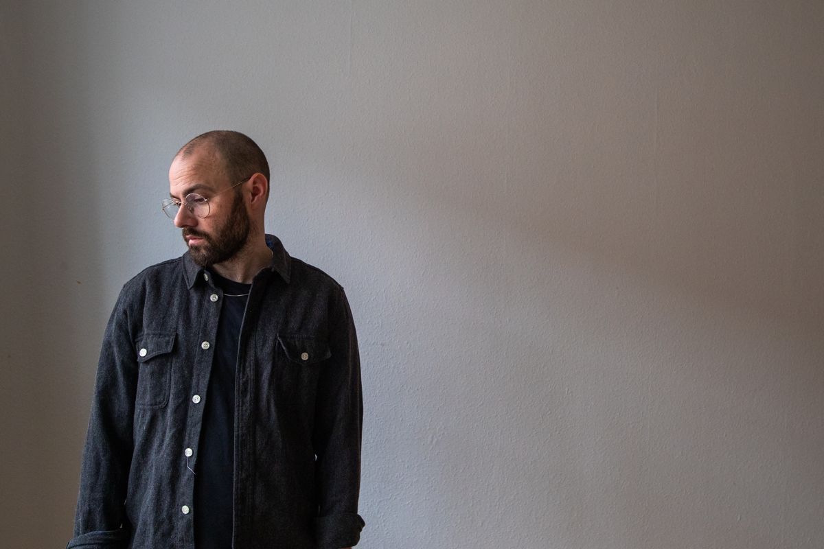 Marc Facchini in a dark shirt against a pale wall